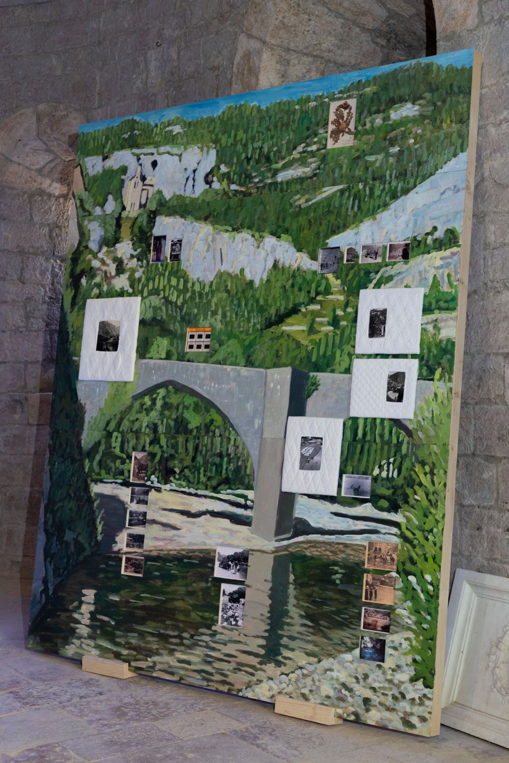 Aux souvenirs des gorges du Tarn : grande peinture du pont de Sainte-Énimie, parsemée de photographies et de cadres matelassés, Chapelle Sainte-Madeleine
